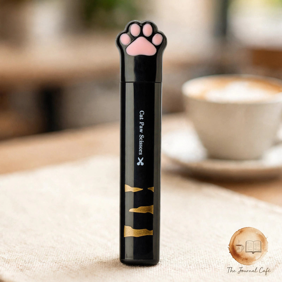 Cat paw mini folding scissors — product photo 12 styled on a cream café table, The Journal Café