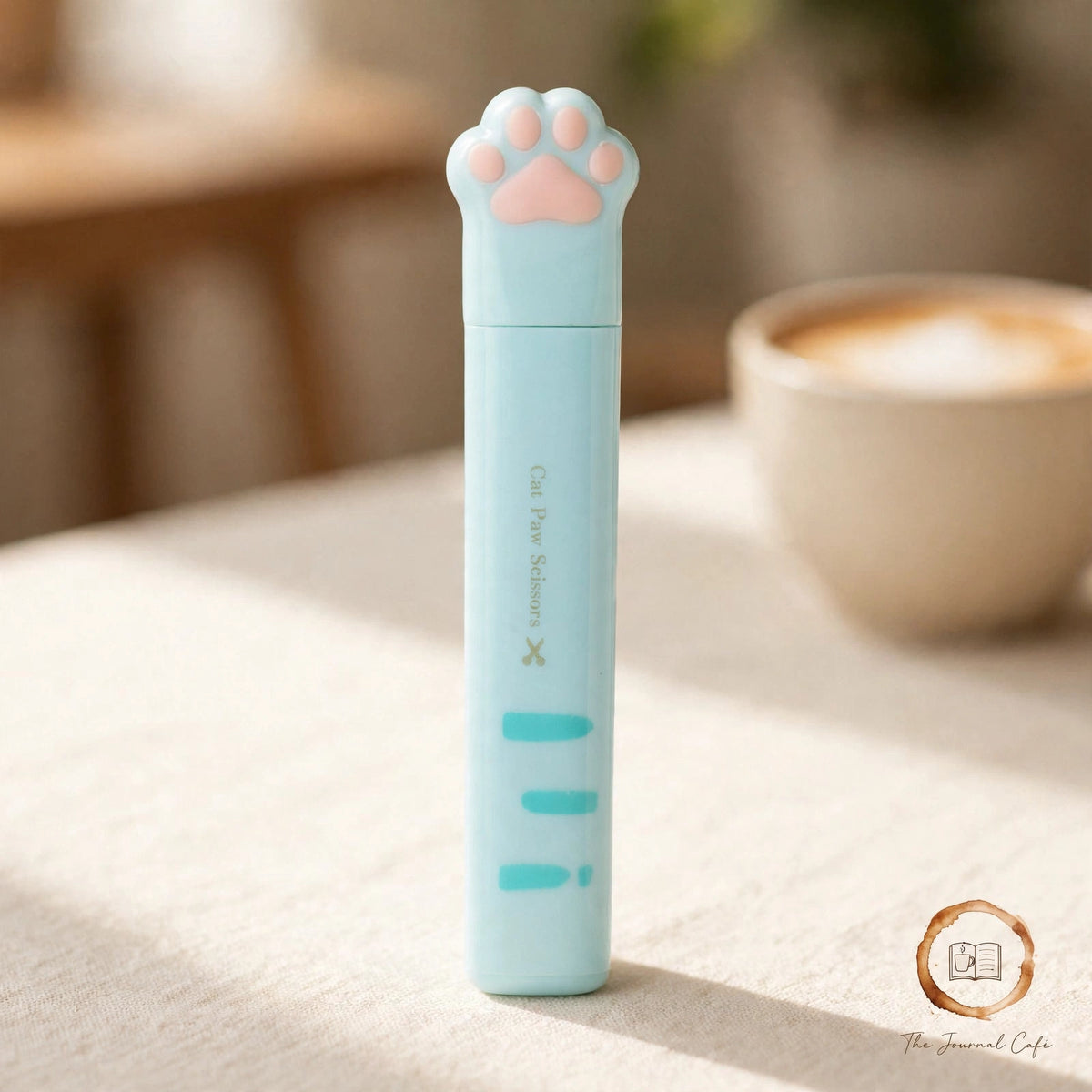 Cat paw mini folding scissors — product photo 6 styled on a cream café table, The Journal Café