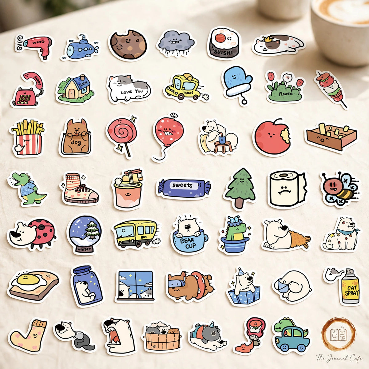 Cartoon animal hotel stickers — product photo 4 styled on a cream café table, The Journal Café