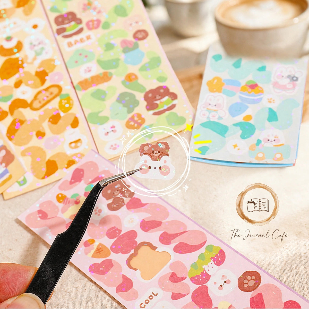 Holographic laser sticker sheets — product photo 3 styled on a cream café table, The Journal Café