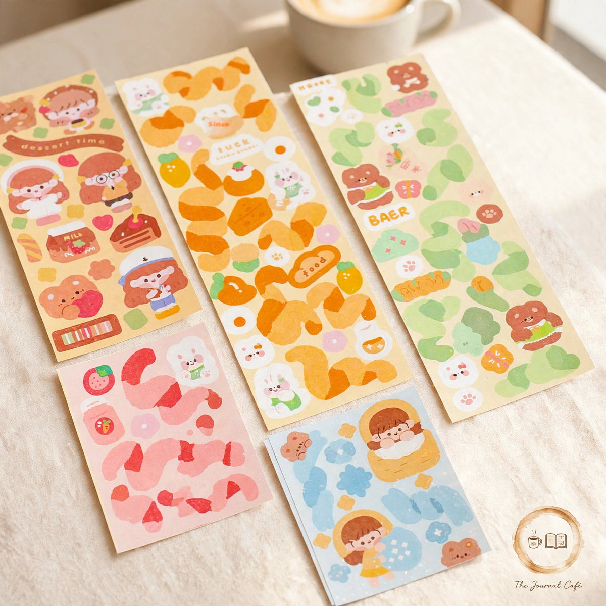 Holographic laser sticker sheets — product photo 8 styled on a cream café table, The Journal Café