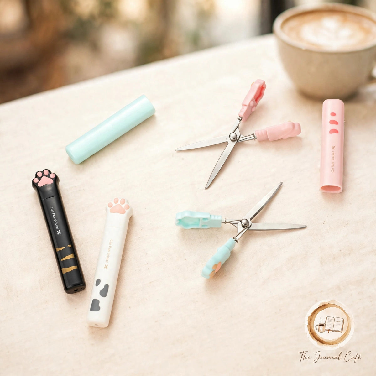 Cat paw mini folding scissors — product photo 5 styled on a cream café table, The Journal Café