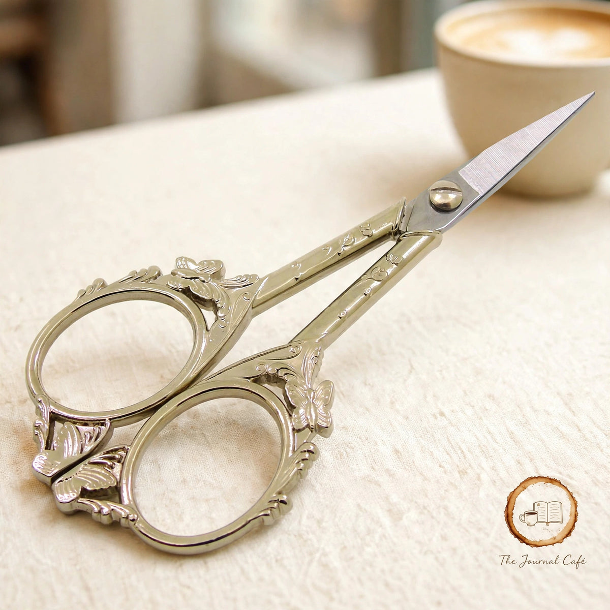 Butterfly retro scissors — product photo 3 styled on a cream café table, The Journal Café